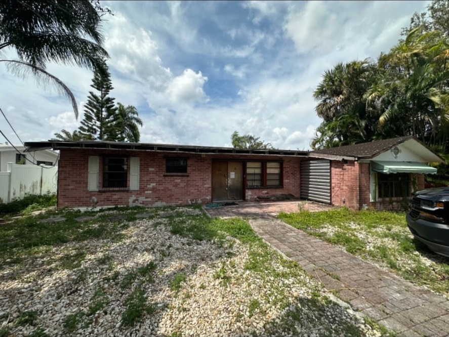 Brick ranch house with its yard, still standing, before demolition